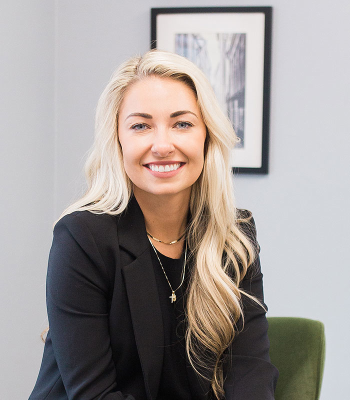 A portrait photo of Dr. Lovell, of Urbana & Darby Dental Smiles, wearing a suit and smiling in the office.